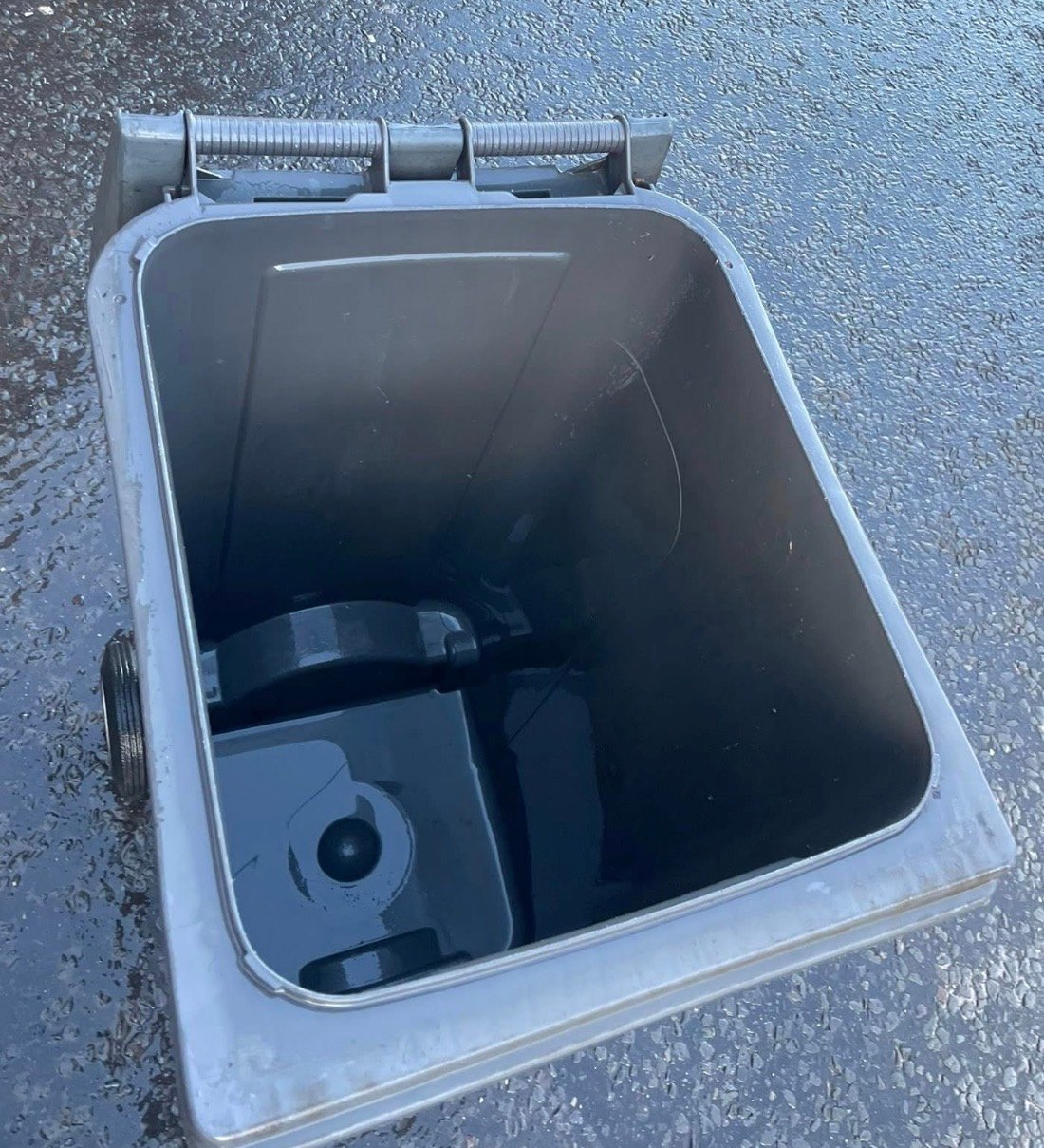 Open gray plastic storage container with hinged lid and handles, showing empty interior